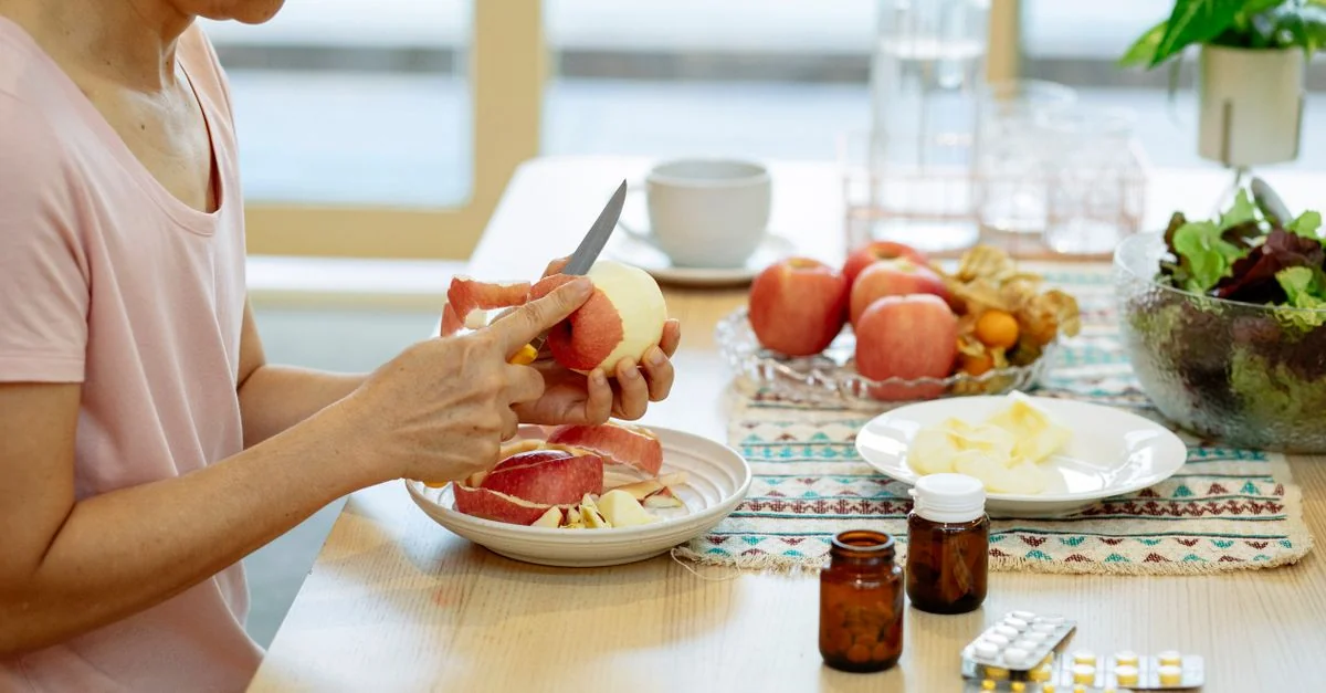 Suplementos vitamínicos sobre a mesa junto com frutas e uma refeição